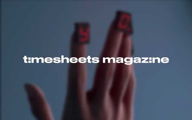 'Timesheets Magazine' logo with a photo of a hand in the background