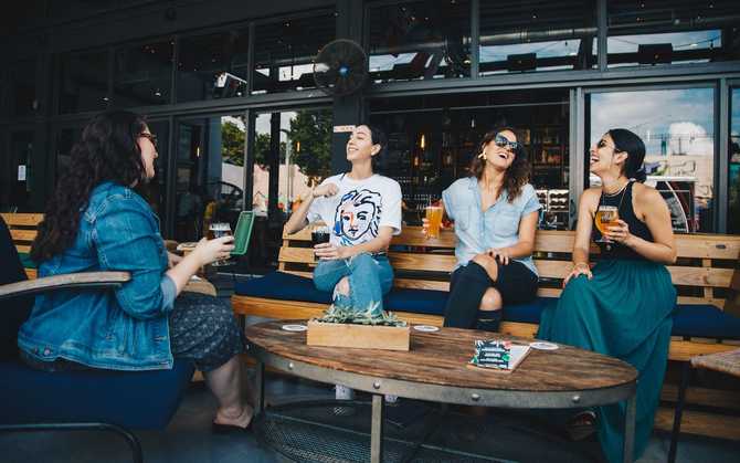 Photo of four people laughing in a cafe