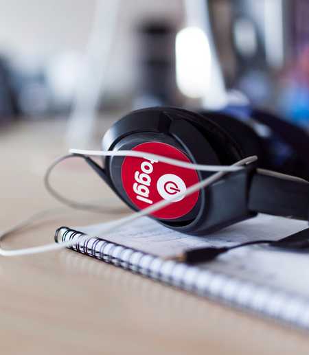Photo of a headphones with a sticker of the old Toggl logo